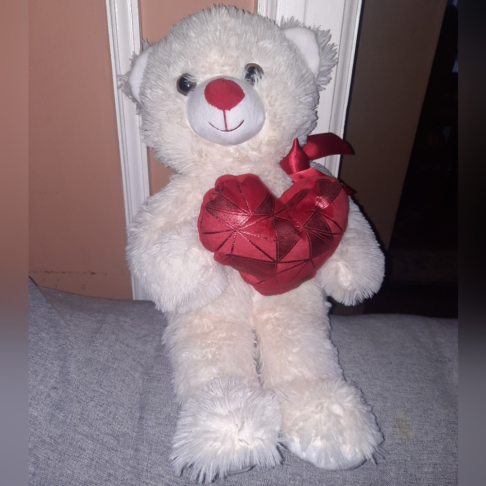 White teddy bear holding heart